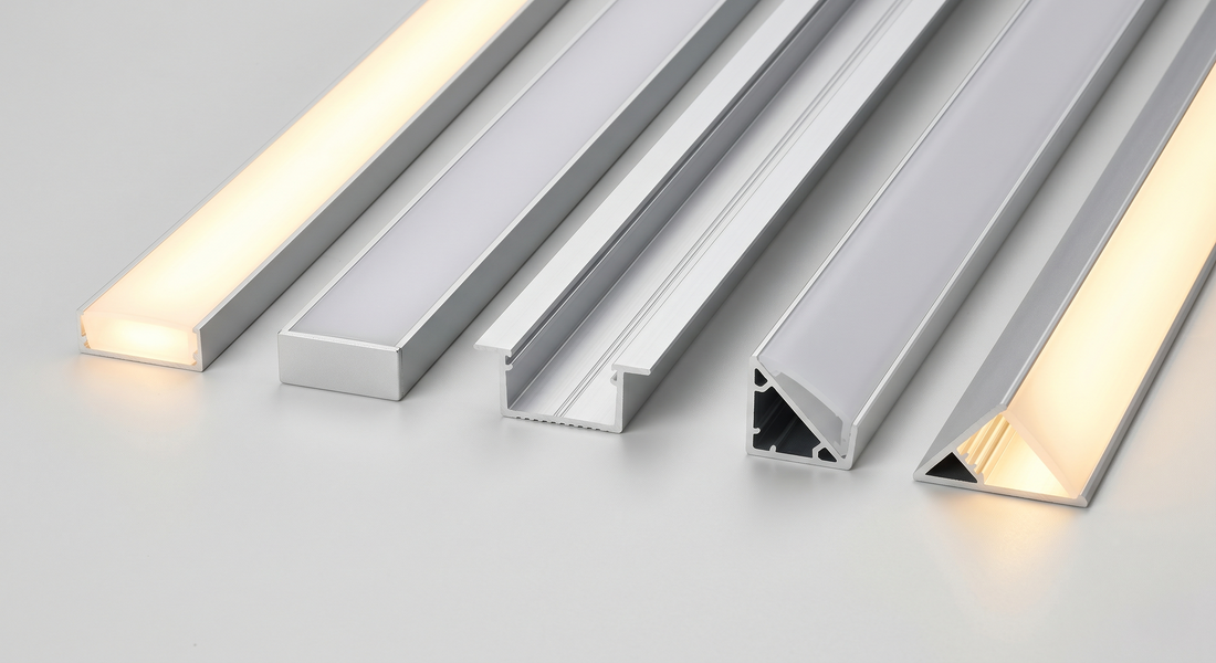 Verschiedene LED-Aluprofile – Aufbau-, Einbau- und Eckprofil – nebeneinander, teils mit warmweiß leuchtendem Diffusor