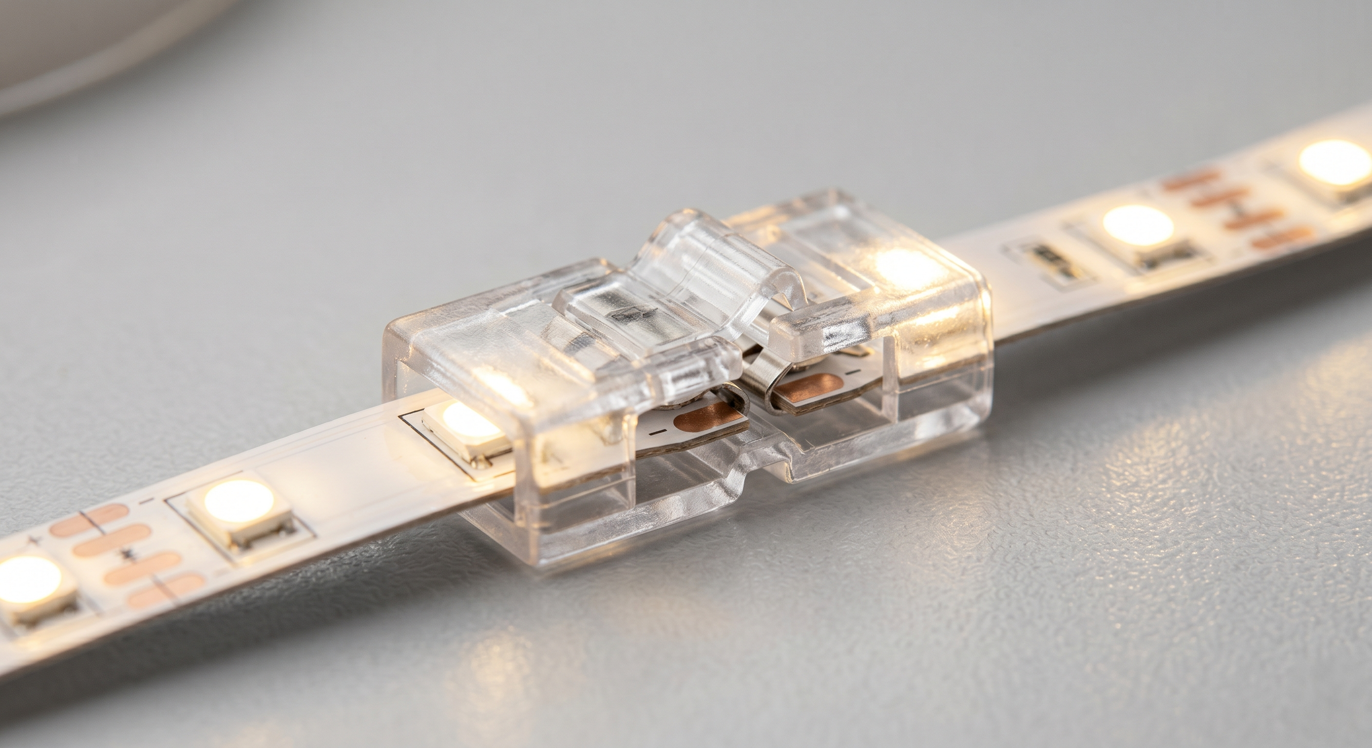 Lötfreier Schnellverbinder, der zwei warmweiß leuchtende LED-Streifen ohne Werkzeug miteinander verbindet